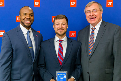 Curtis Taylor, Ph.D. and President Fuchs with Thomas Lutza holding award