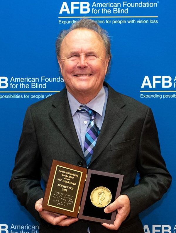 Ted Henter, BSME '74, holds the Migel Medal.