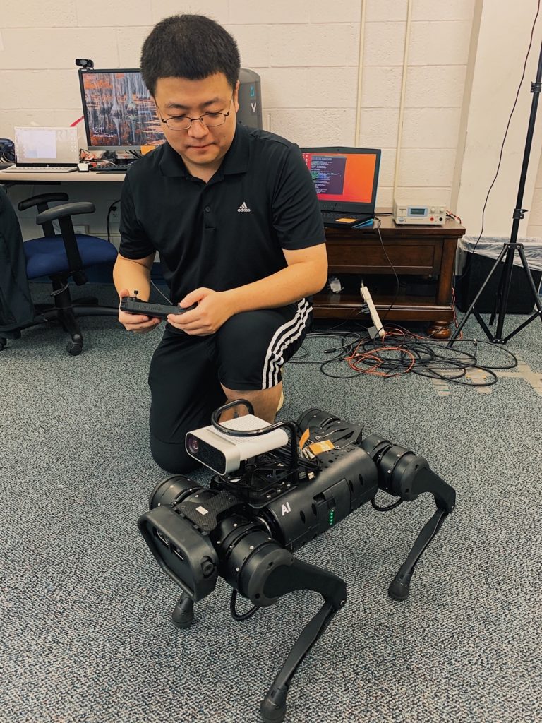 Fang Xu, a doctoral student from the group working with Professor Eric Jing Du, operates a test version of the robotic dog. (Arlett Villalona/WUFT News)