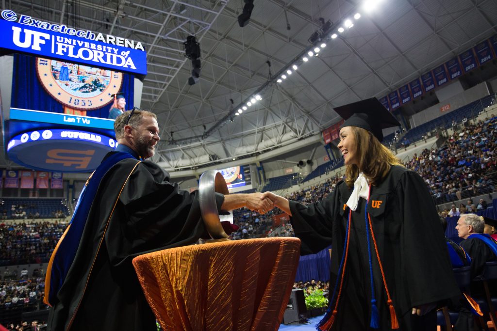 Student shakes hand through Order of the Engineer ring.
