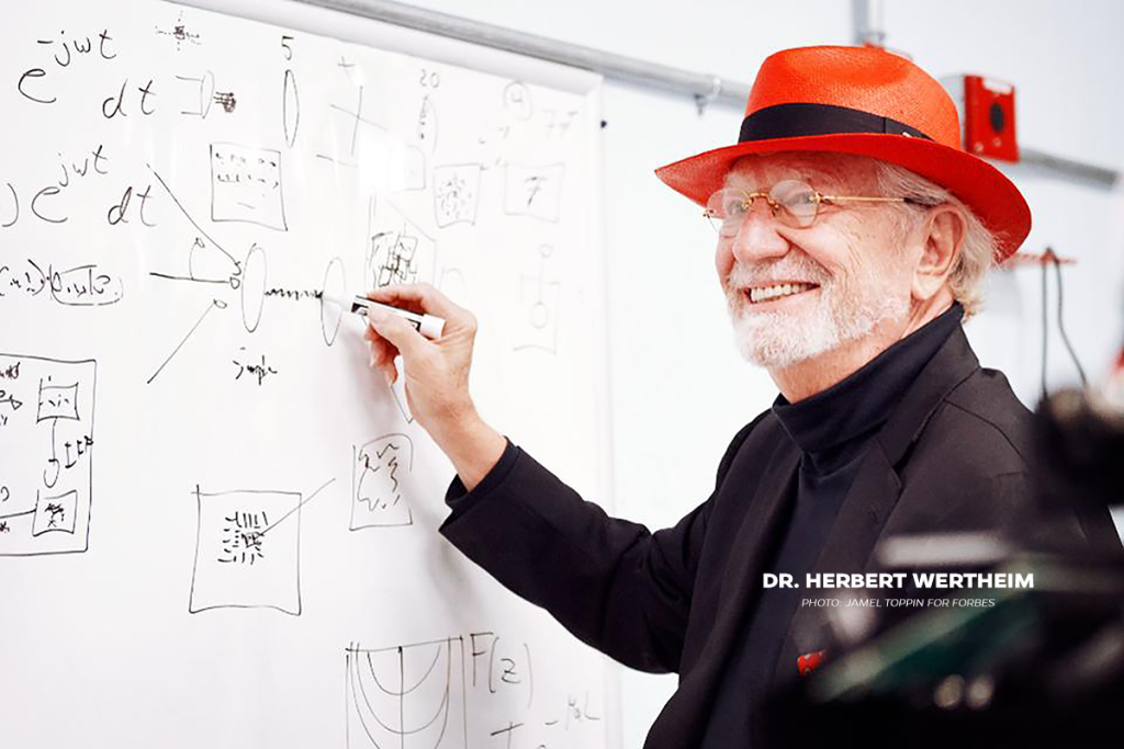 Dr. Herbert Wertheim writing on whiteboard