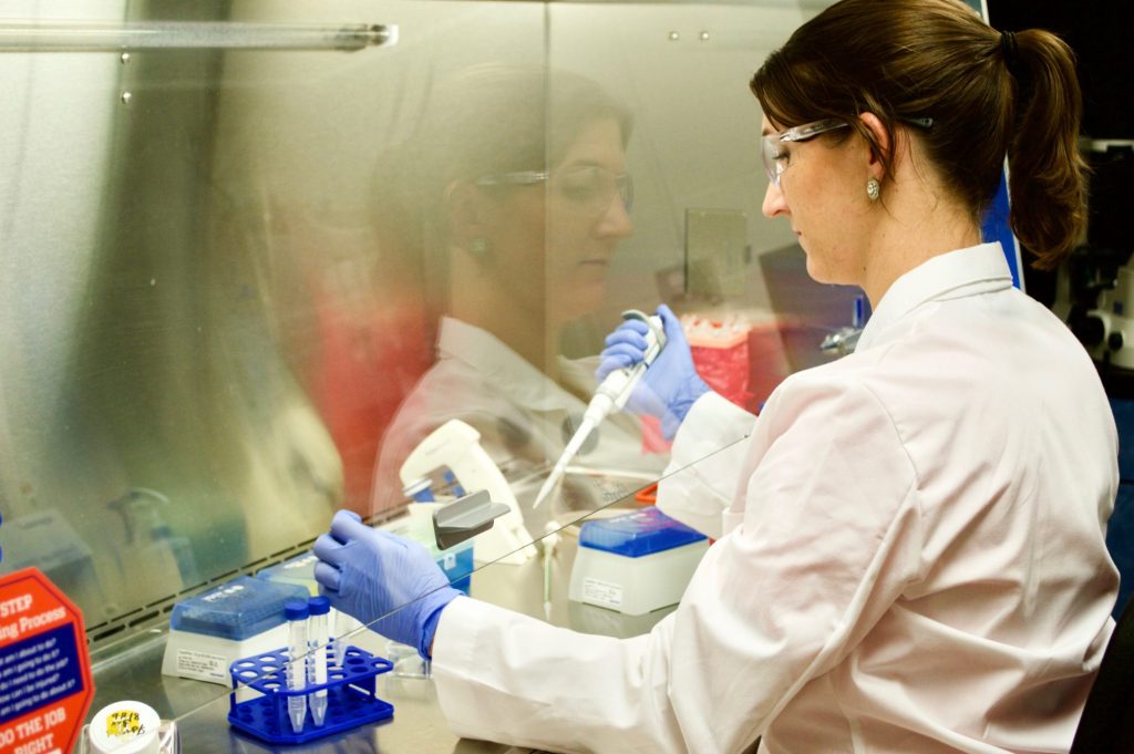 Research with microscope. Proteins shown on computer screen.