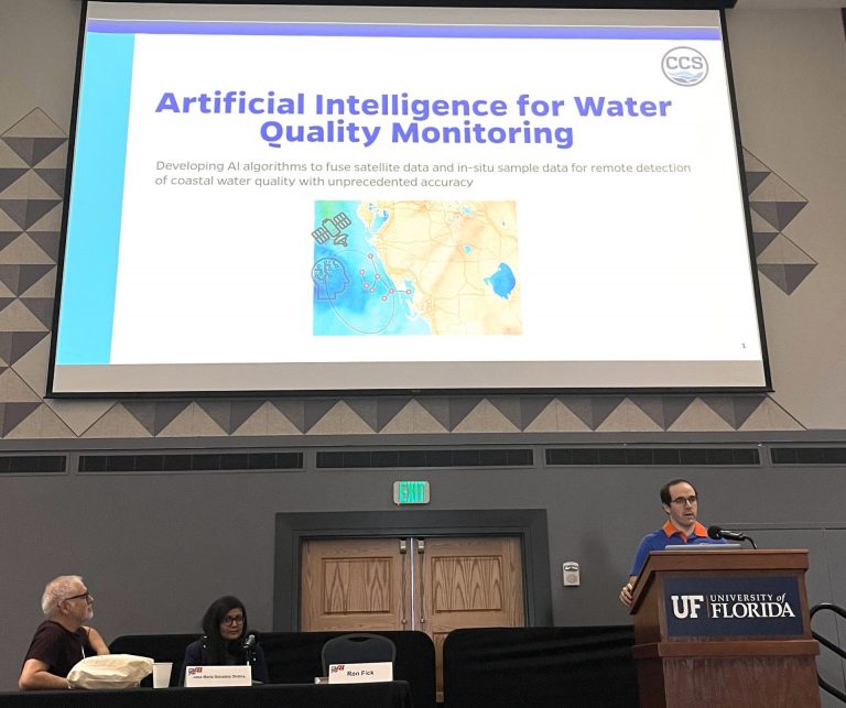 Presenters standing in front of a powerpoint presentation.