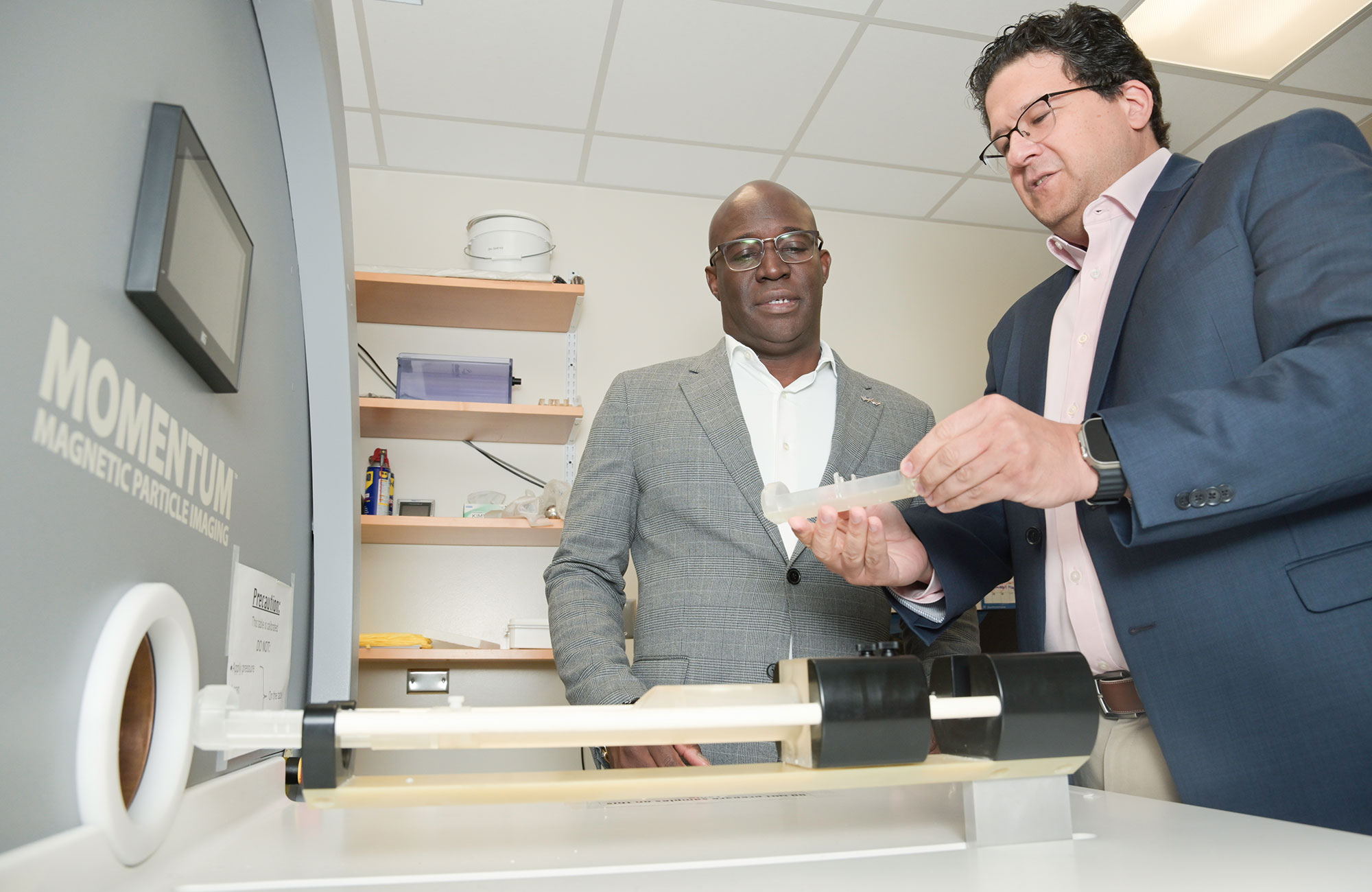 Duane Mitchell, M.D., Ph.D., left, and Carlos Rinaldi-Ramos, Ph.D., by UF's magnetic particle imaging scanner.