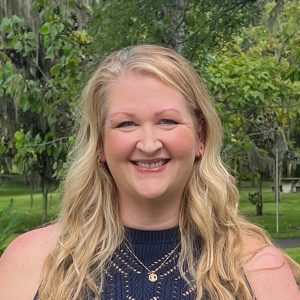 A woman with blonde hair smiling for a headshot photo. 