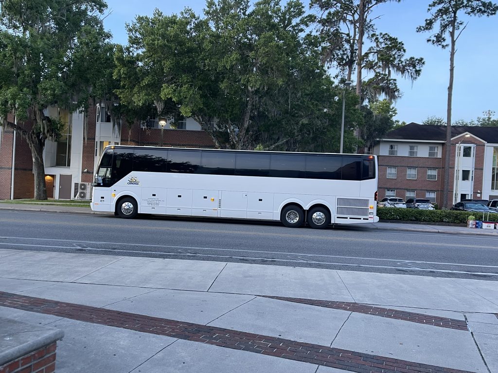 A charter bus parked in front of an apartment building. 