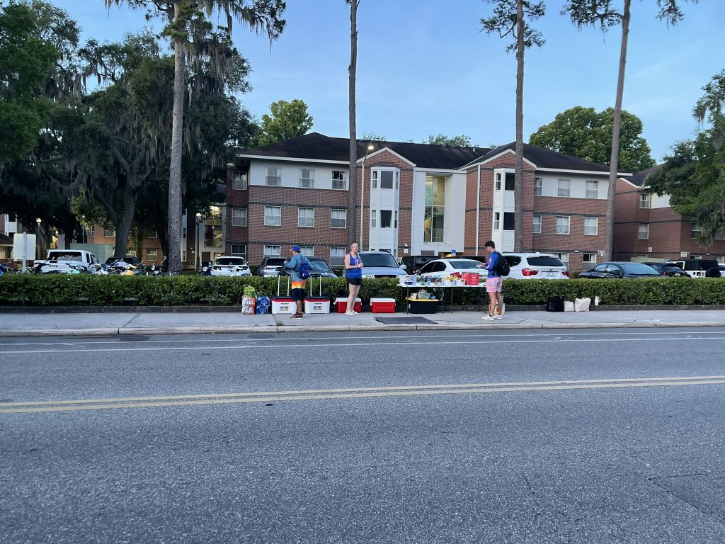 Staff and a student standing around snacks and drinks. 
