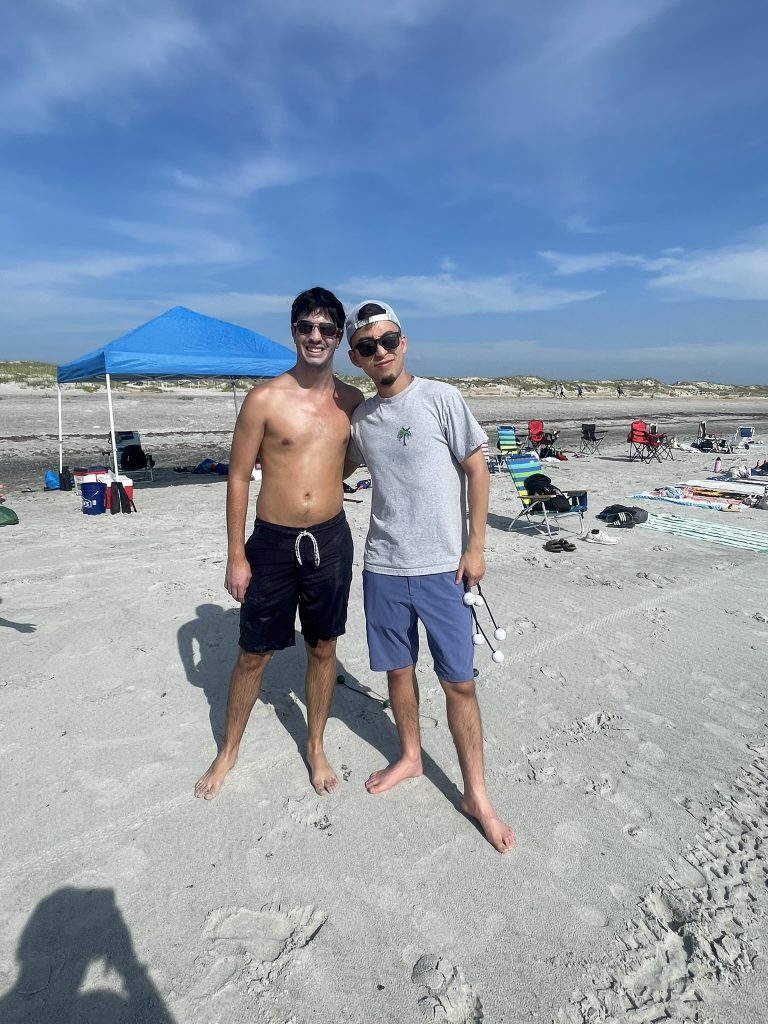 Two male students posing together during their ladder golf participation. 