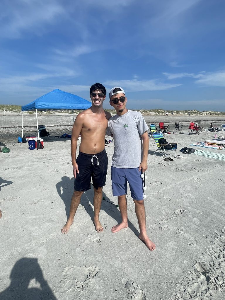 Two male students posing together during their ladder golf participation. 