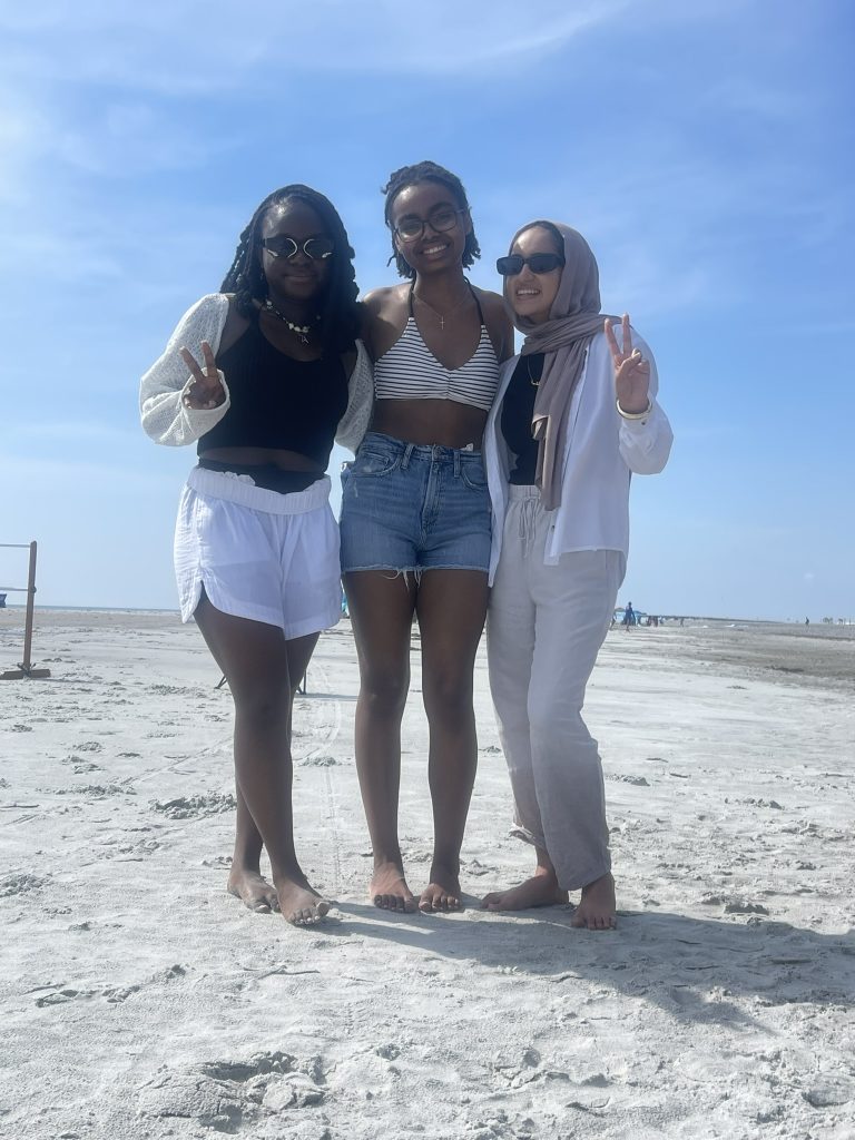 A trio of female students smiling and posing. 