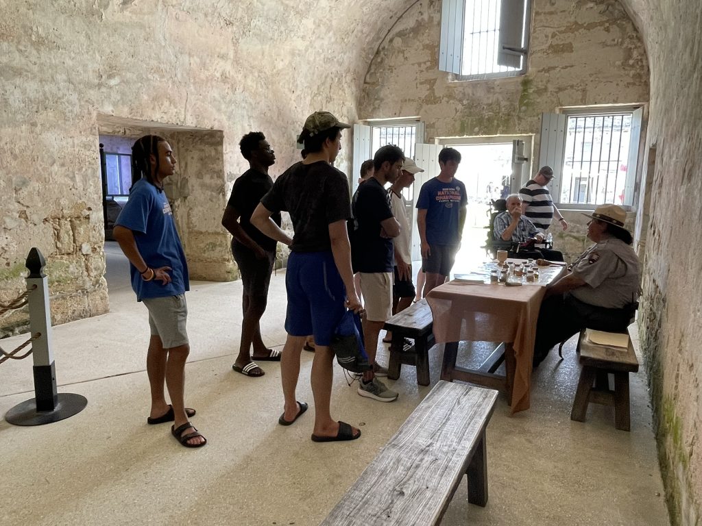 Students speaking with a park ranger about artifacts. 