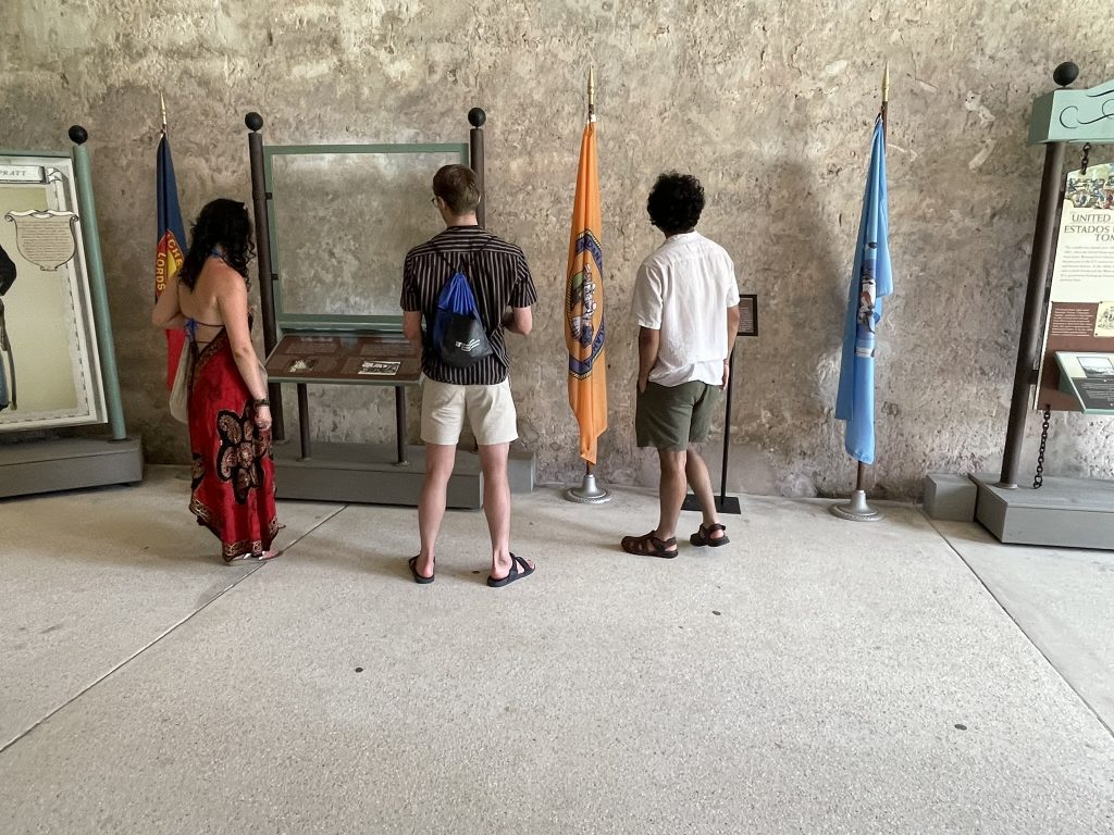 Students observing flag and reading informational signs. 