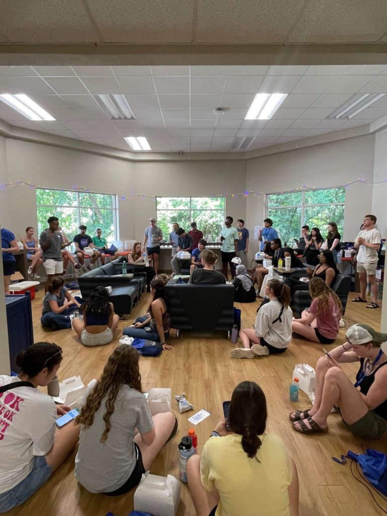 A staff member speaking to a room full of students. 