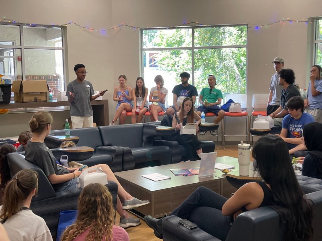 A staff member speaking to a room full of students. 