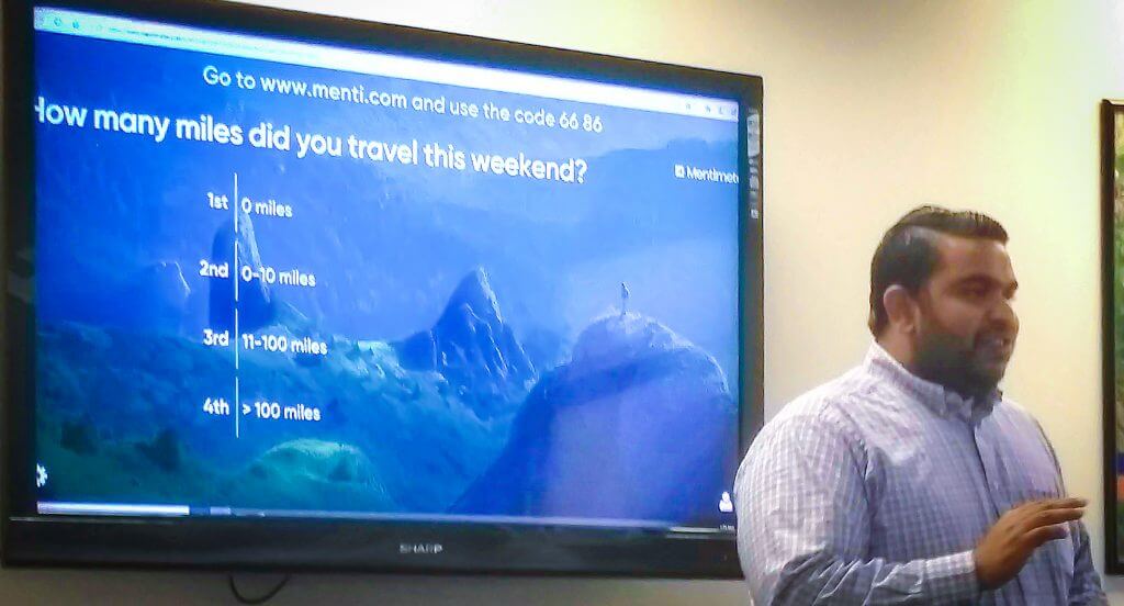 Dr. Nithin Agarwal stands in front of a Power Point presentation