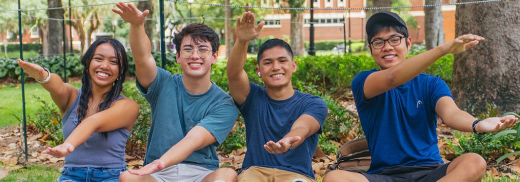 Community resources - photograph of four students doing the Gator chomp